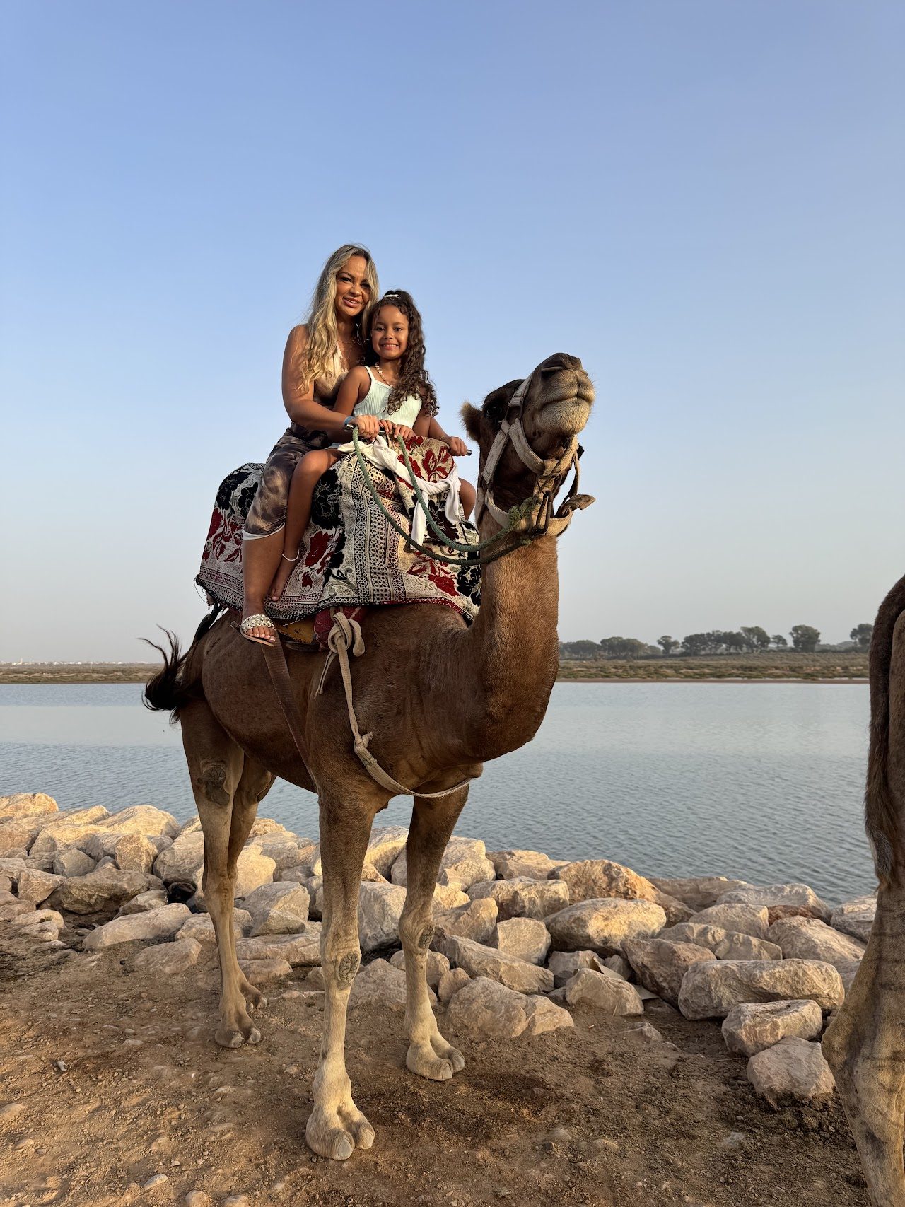 Deux visiteurs à dos de dromadaire devant l’estuaire du Souss près d’Agadir