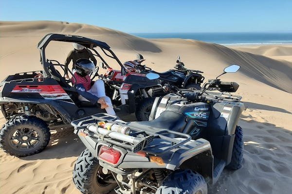 Quads and buggies lined up together on the dunes above the Atlantic