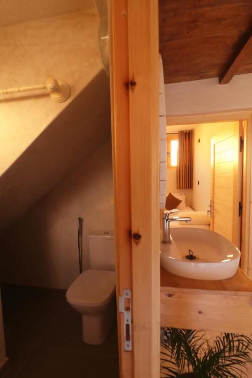 Salle de bain partagée en bois et blanc, plantes et déco bohème