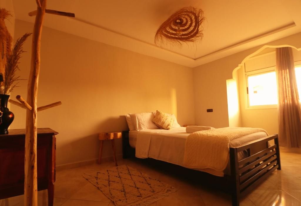 Double room at hyle Surfhouse: queen bed under warm lamplight with a Moroccan rug