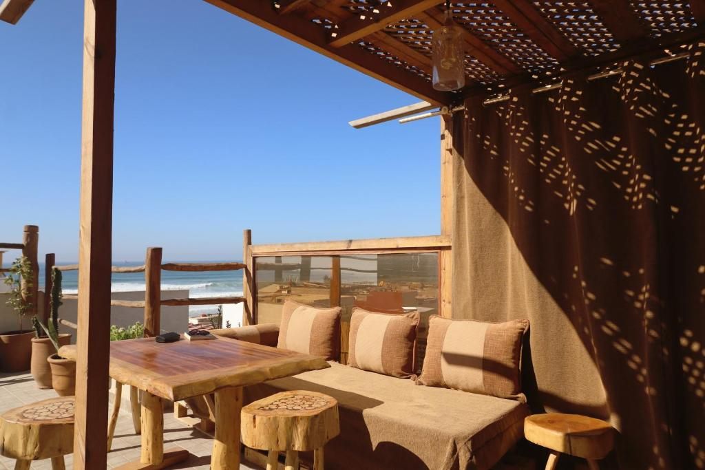 Rooftop lounge with pergola, cushions and the ocean behind