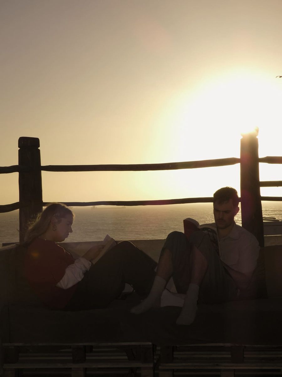 Backlit guests relaxing on the rooftop at sunset