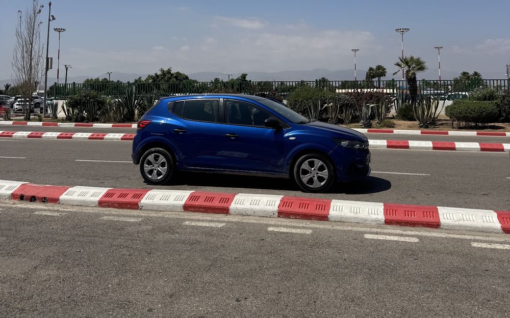 Blue Dacia Sandero driving on the Agadir airport access road